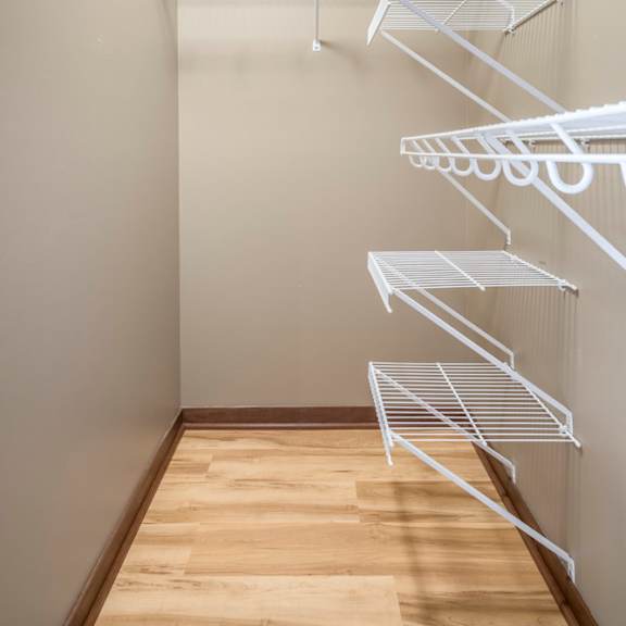 Thumbnail 14 of 24 Empty white shelves in a room with wooden floor.
