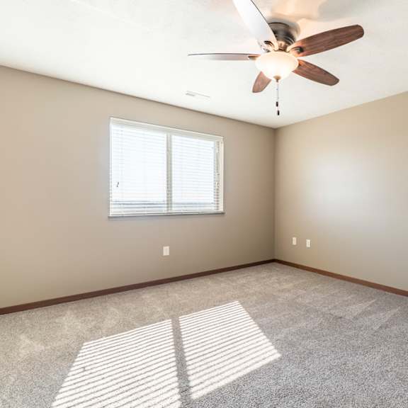 Thumbnail 12 of 24 A room with a ceiling fan and a window.