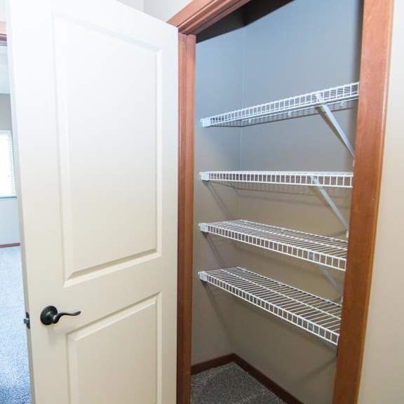 Thumbnail 9 of 14 Empty linen closet with a white door and shelves.