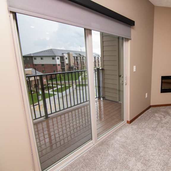 Thumbnail 6 of 9 A living room with a fireplace and sliding glass doors to balcony