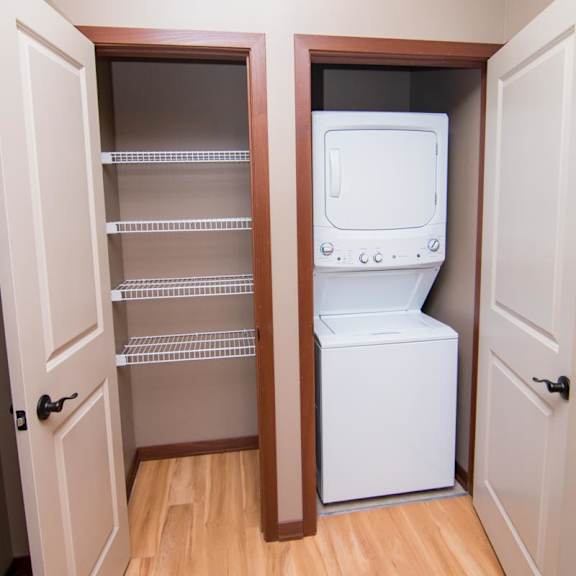 Thumbnail 7 of 9 A stacked washer and dryer in a closet with another linen closet next to it