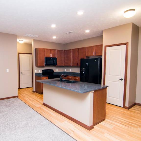 Thumbnail 5 of 9 A kitchen area with an island and cabinets.