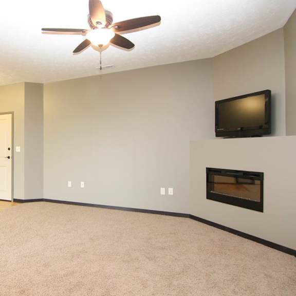 Thumbnail 6 of 14 A living room with a fireplace and a television.
