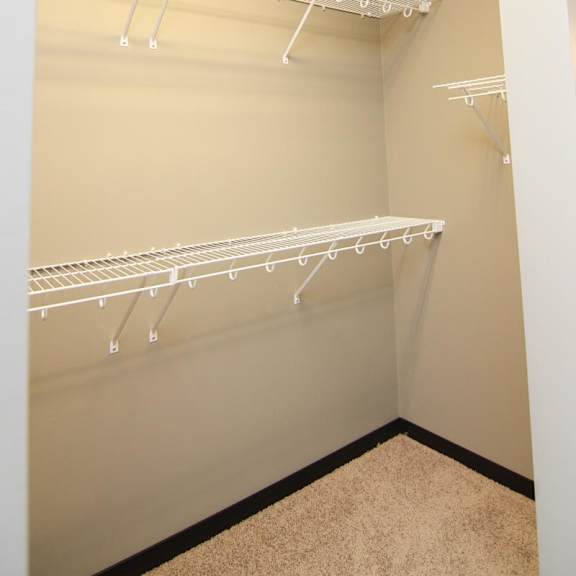 Thumbnail 11 of 14 Empty white shelves in a walk-in closet.