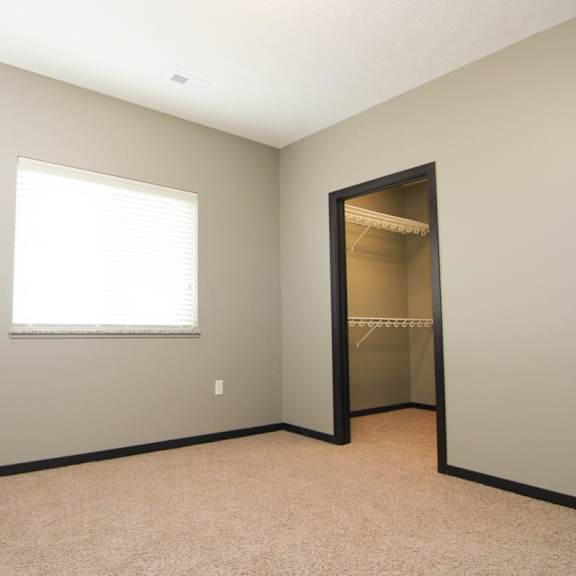 Thumbnail 10 of 14 A room with a window and a closet.