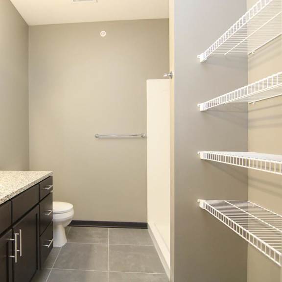 Thumbnail 22 of 24 A bathroom with a sink, toilet, and shelves.