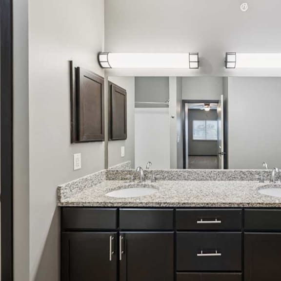 Thumbnail 22 of 33 A bathroom with double sink granite vanity, an oversized mirror, and a medicine cabinet.