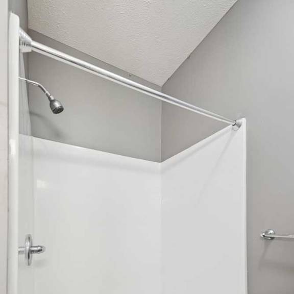 Thumbnail 23 of 33 A bathroom with a walk-in shower with chrome fixtures.