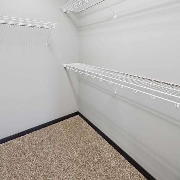Thumbnail 31 of 33 Empty walk-in closet with white walls and shelves.