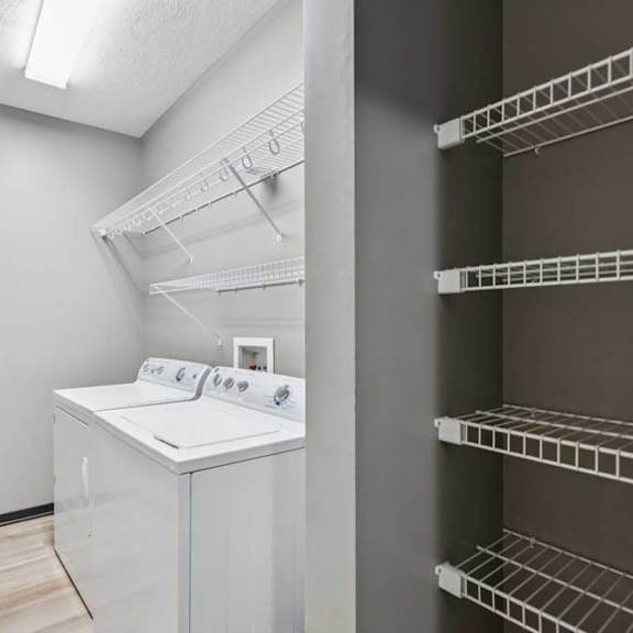 Thumbnail 32 of 33 A laundry room with a full-sized washer and dryer, and overhead storage.