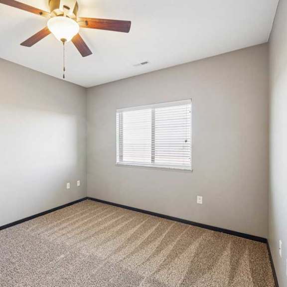 Thumbnail 23 of 30 Empty bedroom with carpet, neutral walls, and a window with blinds providing natural light.