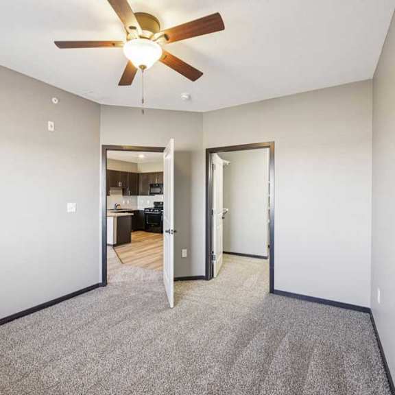 Thumbnail 24 of 30 Bedroom with carpet and ceiling light, featuring an open closet and direct access to a bathroom with wood-style flooring.