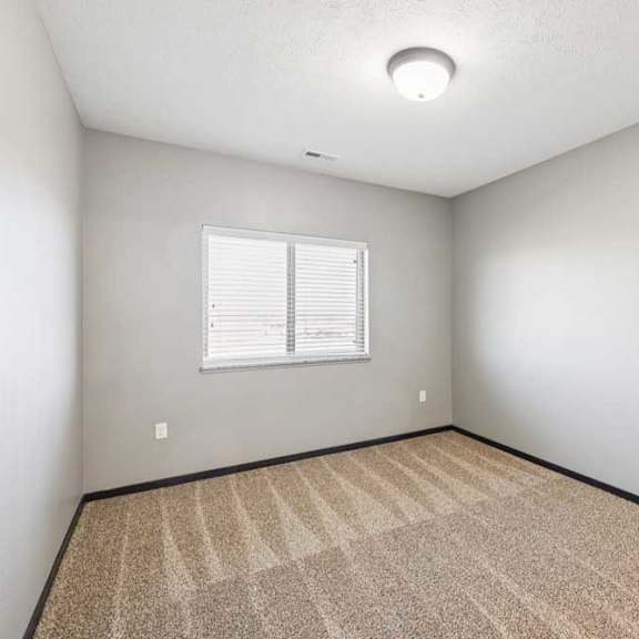 Thumbnail 28 of 30 A room with a carpeted floor and a window with blinds.