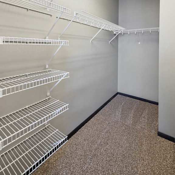 Thumbnail 30 of 30 Walk-in closet with extensive white wire shelving along multiple walls and carpeted floor.