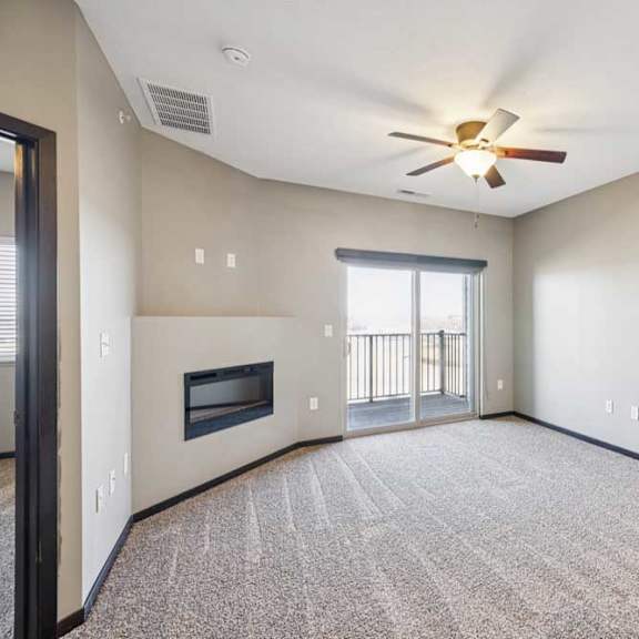 Thumbnail 19 of 30 A spacious living room with a fireplace and a ceiling fan.