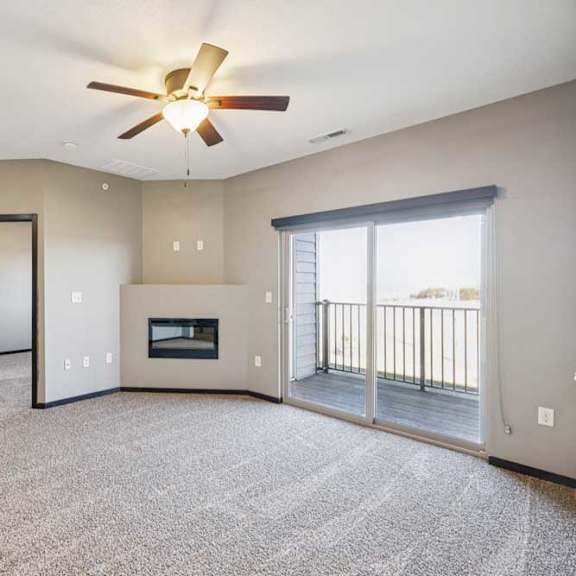 Thumbnail 18 of 30 A spacious living room with a fireplace and sliding glass doors.