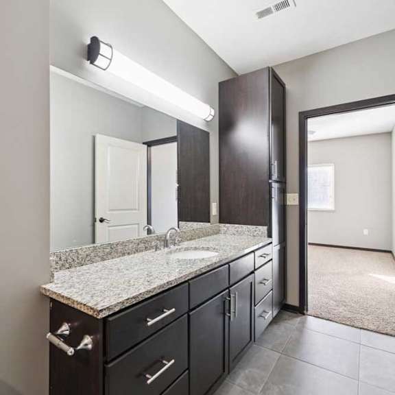 Thumbnail 20 of 23 A bathroom with a sink, mirror, and cabinets.