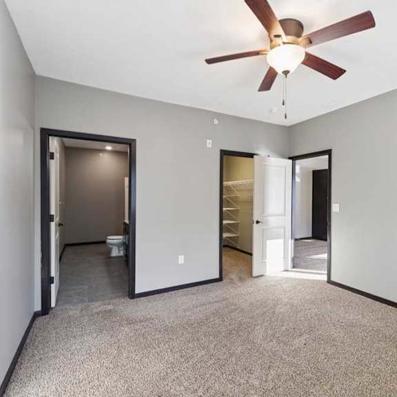 Thumbnail 16 of 23 A room with a ceiling fan and carpeted floor.