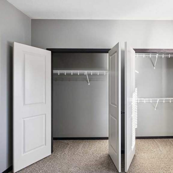 Thumbnail 13 of 23 A white closet with two doors open and shelves.