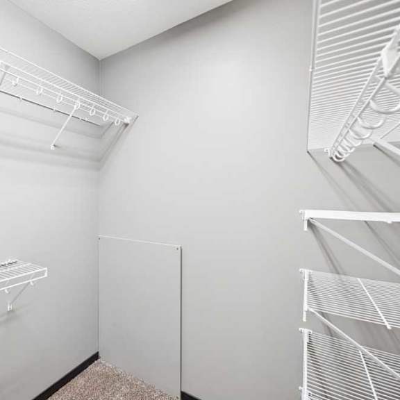 Thumbnail 17 of 23 Empty white walk-in closet with shelves and hangers.