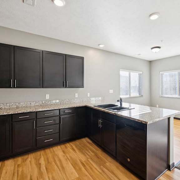 Thumbnail 5 of 23 A kitchen with black cabinets and a granite countertop.