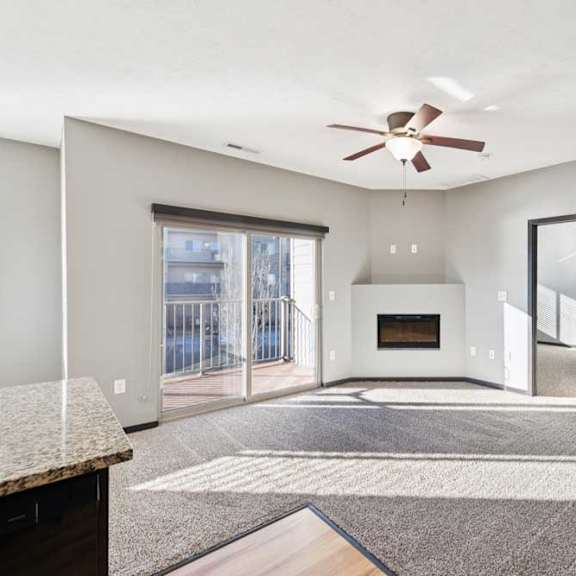 Thumbnail 8 of 23 A spacious living room with a fireplace and a ceiling fan.