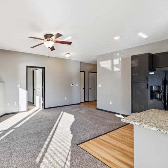 Thumbnail 10 of 23 A modern living room with a fireplace and a ceiling fan.