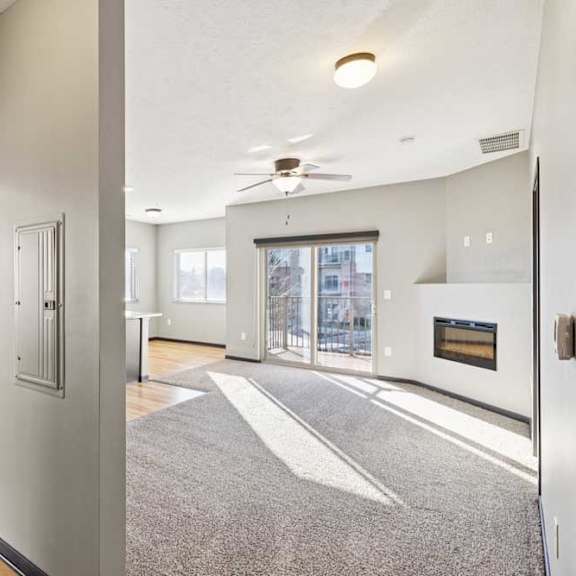 Thumbnail 11 of 23 A modern open doorway leads to a living room with a fireplace.