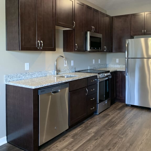 Thumbnail 2 of 16 Kitchen with dark brown cabinets and matching stainless steel appliances in a studio apartment at the flats at shadow creek