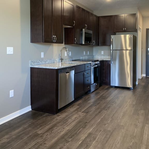 Thumbnail 6 of 16 Kitchen with dark brown cabinets and matching stainless steel appliances in a studio apartment at the flats at shadow creek