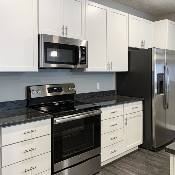 Thumbnail 4 of 20 White cabinetry and matching stainless steel appliances in the kitchen of the buffalo floorplan at the flats at shadow creek