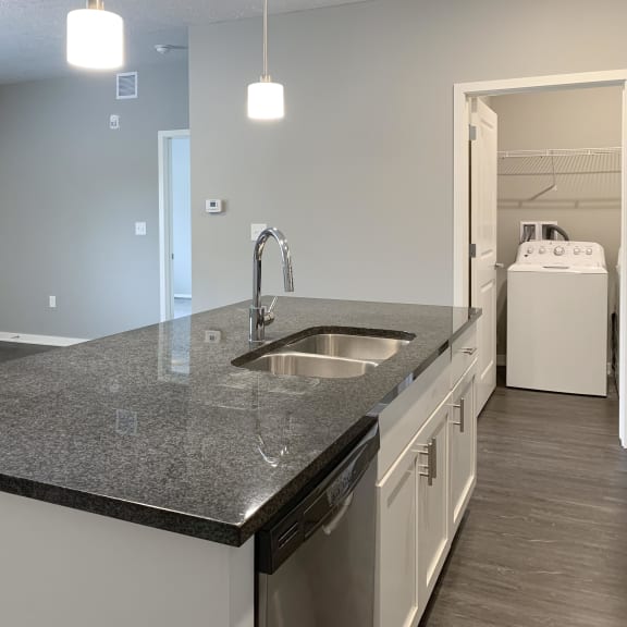 Thumbnail 6 of 23 large dark granite countertop island with view of dining room The Flats at Shadow Creek in Lincoln Nebraska