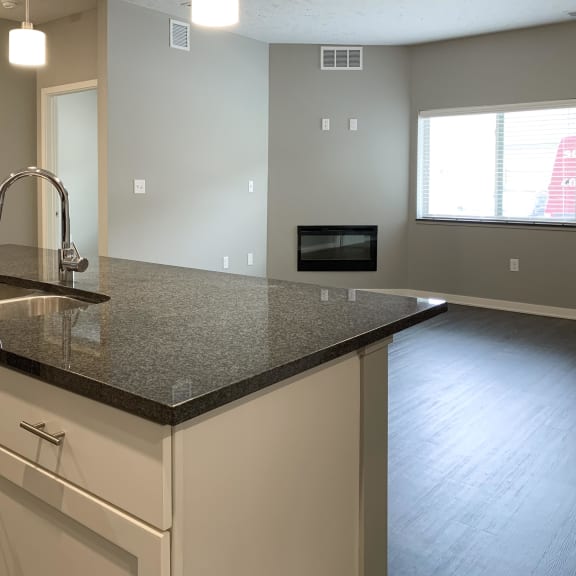 Thumbnail 5 of 23 large dark granite countertop island with view of dining room The Flats at Shadow Creek in Lincoln Nebraska