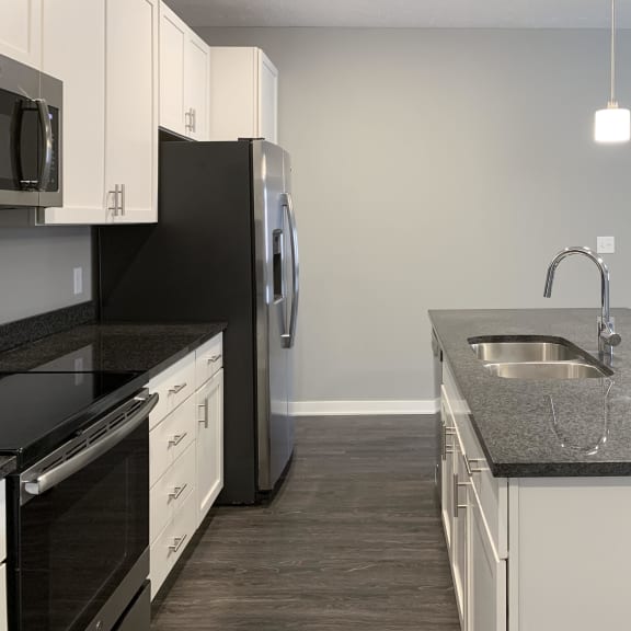 Thumbnail 3 of 23 Kitchen with white cabinets and dark granite counters The Flats at Shadow Creek in Lincoln Nebraska