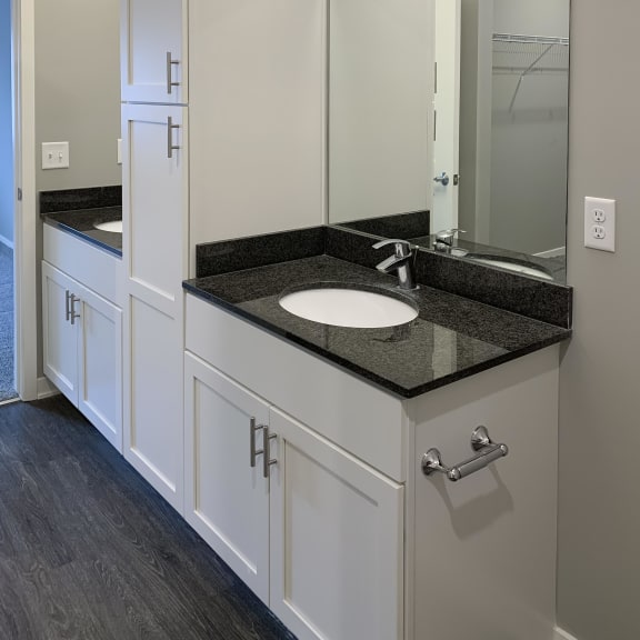 Thumbnail 12 of 23 Bathroom with white vanity for storage and large mirror with great lighting at The Flats at Shadow Creek