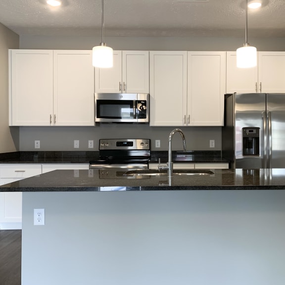 Thumbnail 4 of 23 Kitchen with white cabinets and dark granite counters The Flats at Shadow Creek in Lincoln Nebraska
