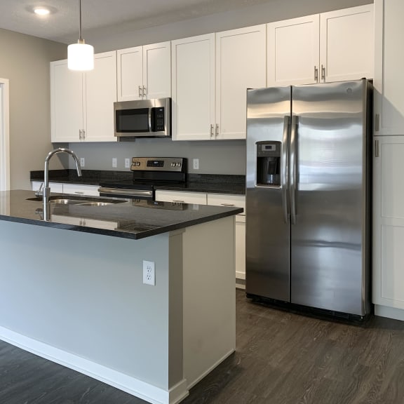 Thumbnail 2 of 23 Kitchen with white cabinets and dark granite counters The Flats at Shadow Creek in Lincoln Nebraska