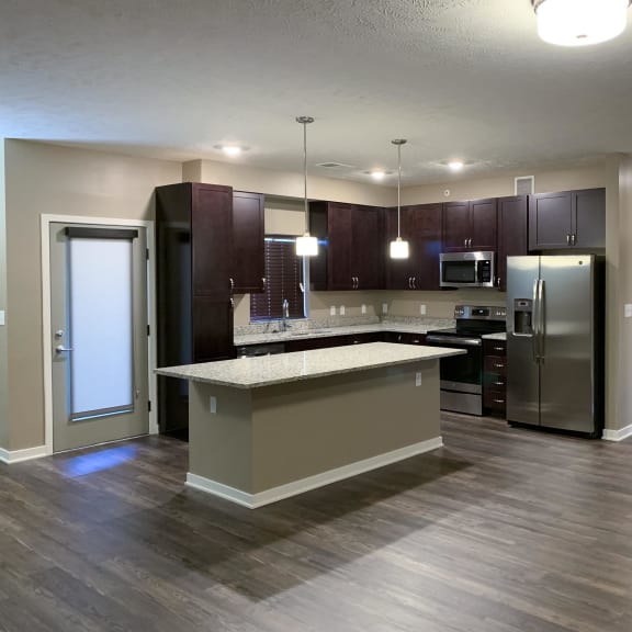 Thumbnail 3 of 15 Kitchen with dark brown cabinets and large kitchen island and matching stainless steel  appliances