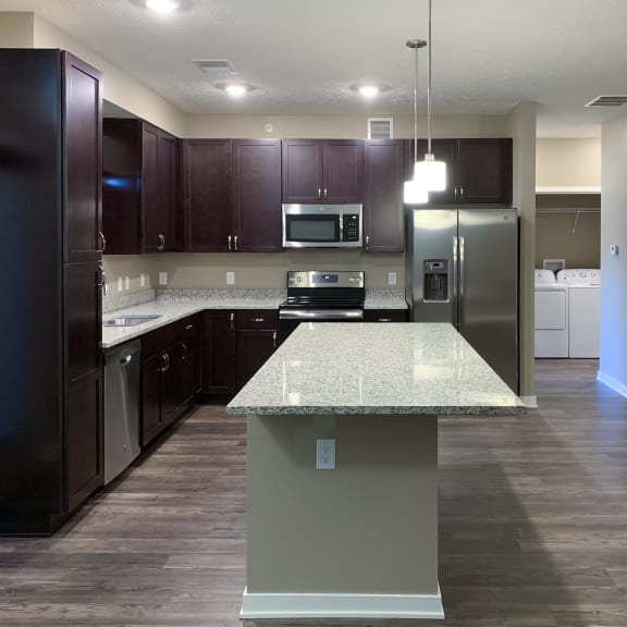 Thumbnail 4 of 15 Kitchen with dark brown cabinets and large kitchen island and matching stainless steel  appliances