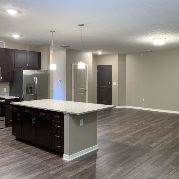 Thumbnail 5 of 15 Large living and dining area with hardwood floors and a granite kitchen island