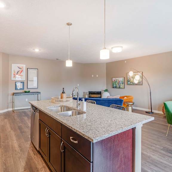 Thumbnail 7 of 15 View of kitchen island and living room at The Flats at Shadow Creek