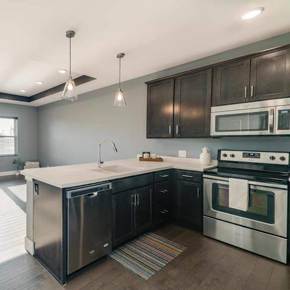 Thumbnail 2 of 16 A modern kitchen with stainless steel appliances and wooden cabinets.
