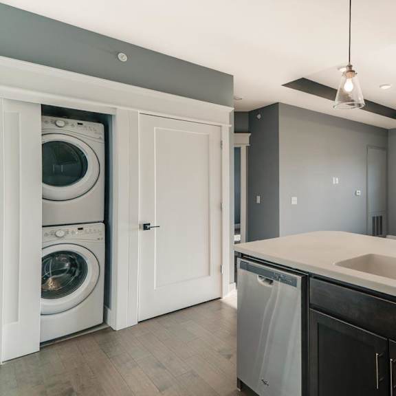 Thumbnail 4 of 16 A modern laundry room with a washer and dryer in the cabinet.