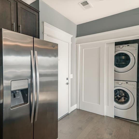 Thumbnail 5 of 16 A modern kitchen with a stainless steel refrigerator and white cabinets.
