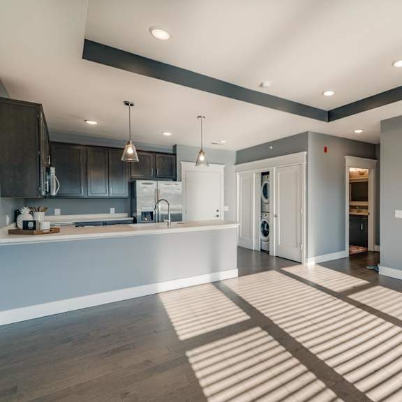 Thumbnail 8 of 16 A modern kitchen with a large peninsula and open living area
