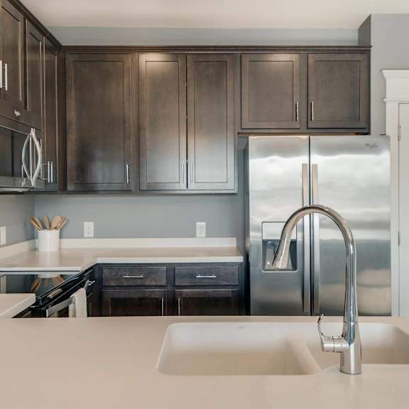 Thumbnail 10 of 16 A modern kitchen with dark brown cabinets and stainless steel appliances.