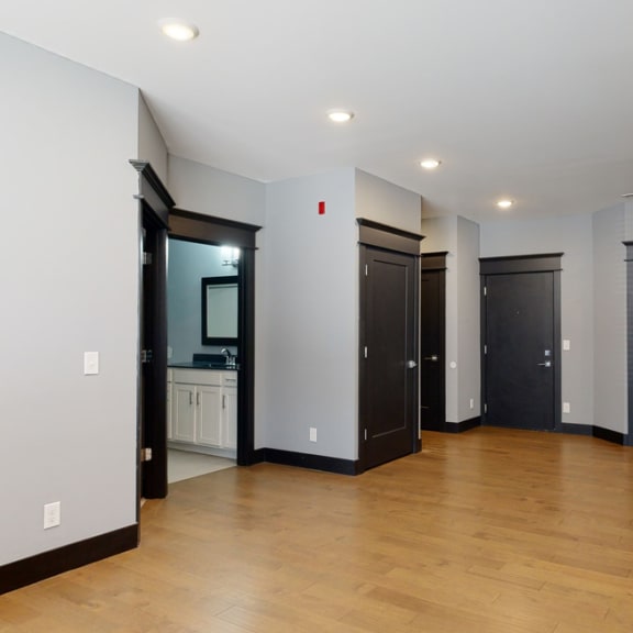 Thumbnail 6 of 14 Living room with light gray walls, black trim, and wooden floors