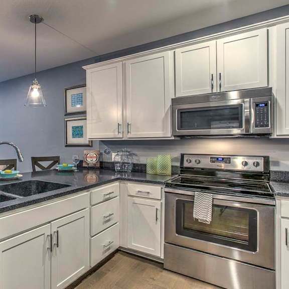 Thumbnail 17 of 23 Large open floor plan kitchen with white cabinetry and stainless steel appliances