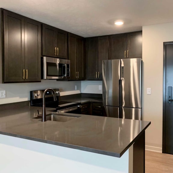 Thumbnail 4 of 20 a kitchen with stainless steel appliances and dark wood cabinets
