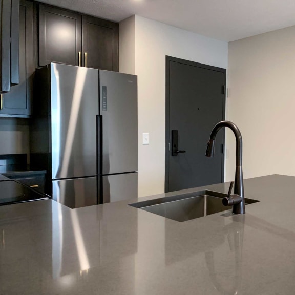 Thumbnail 2 of 20 a kitchen with stainless steel fridge and dark wood cabinets right off the entryway